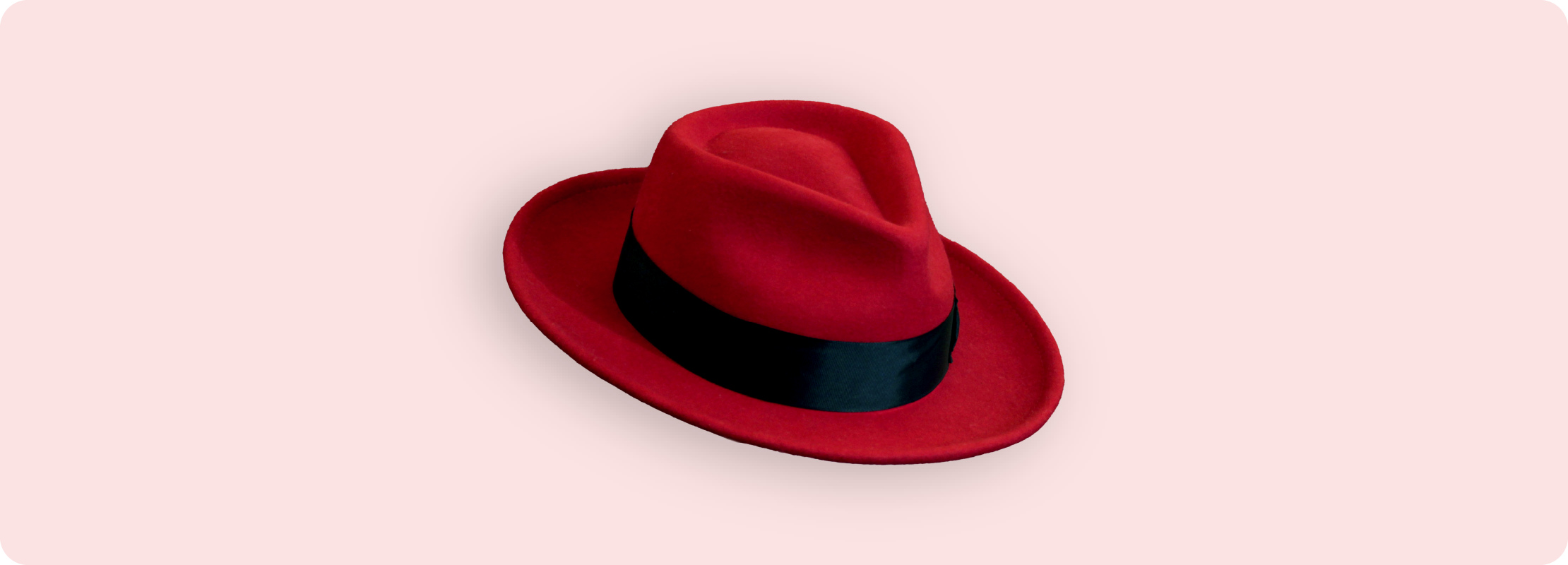 A red fedora made of felt with a black band.
