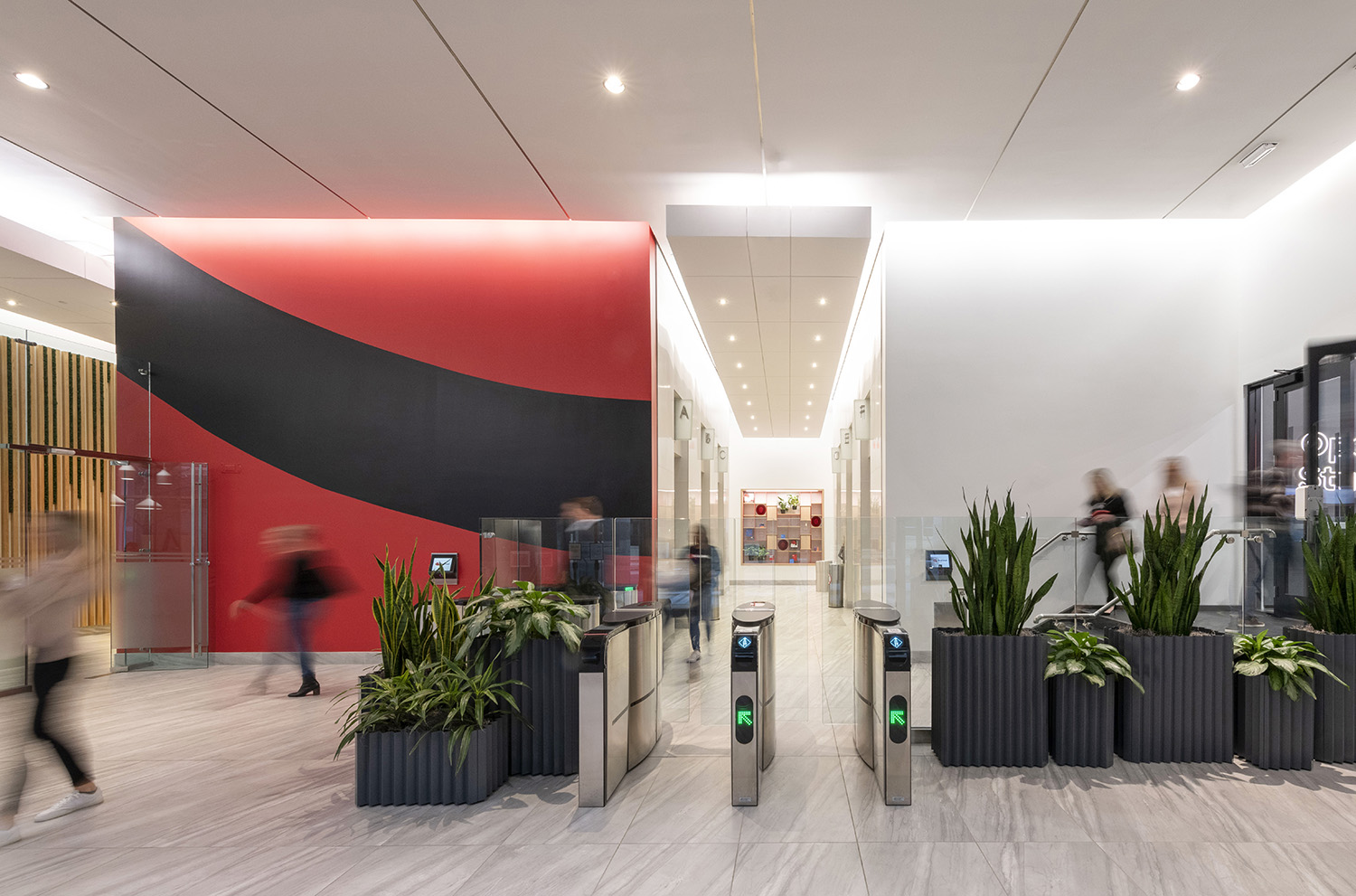 A photo shows people moving through the lobby of Red Hat Tower.