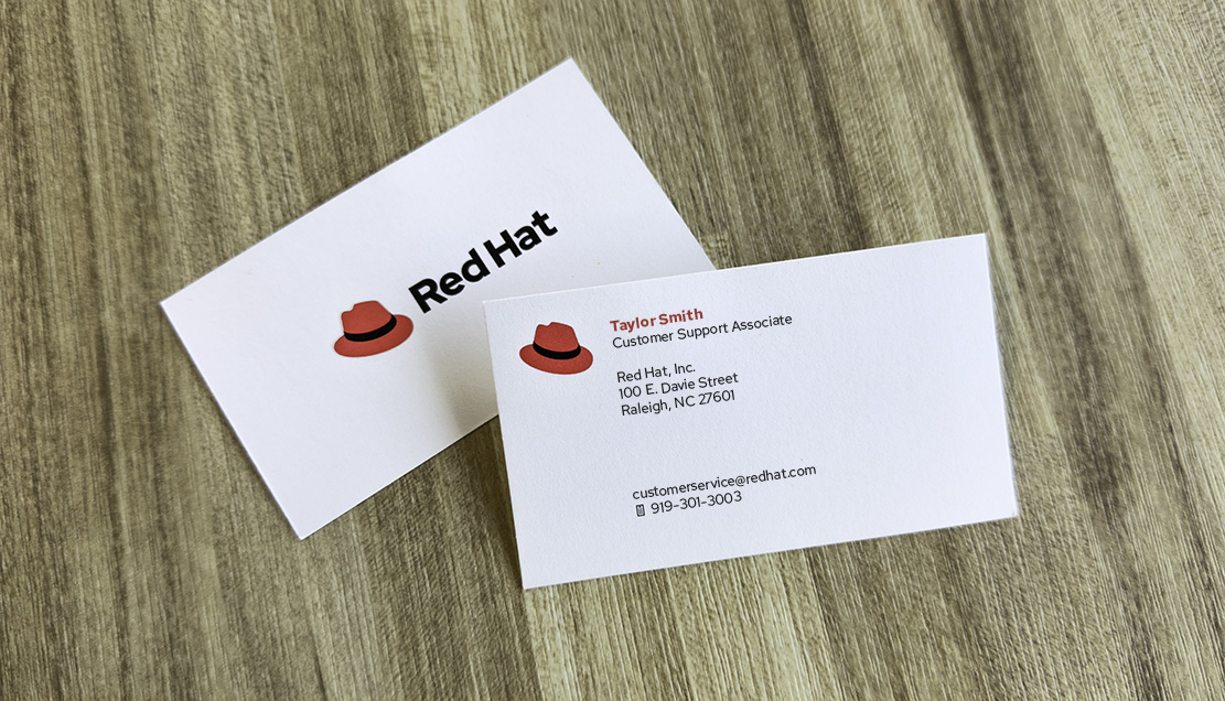 A photo shows a Red Hat business card, which has the hat next to the name of the Red Hatter.
