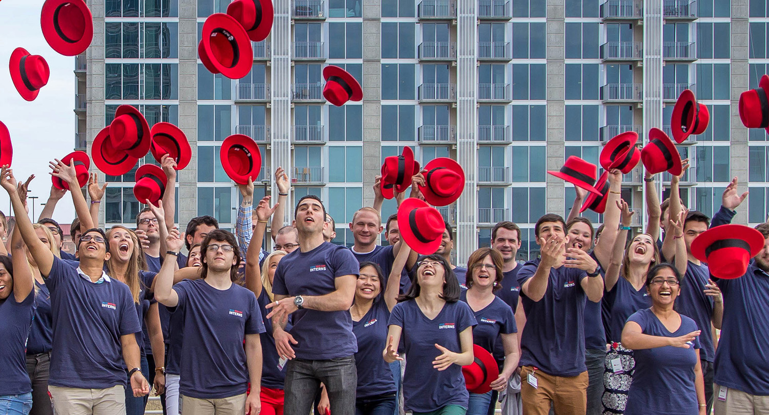A group of Red Hatters toss their fedoras at a celebration.