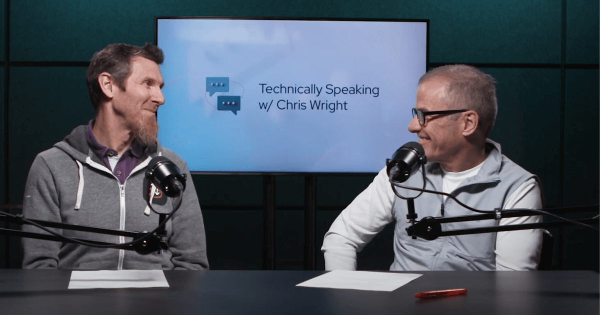 Two men with microphones at desk