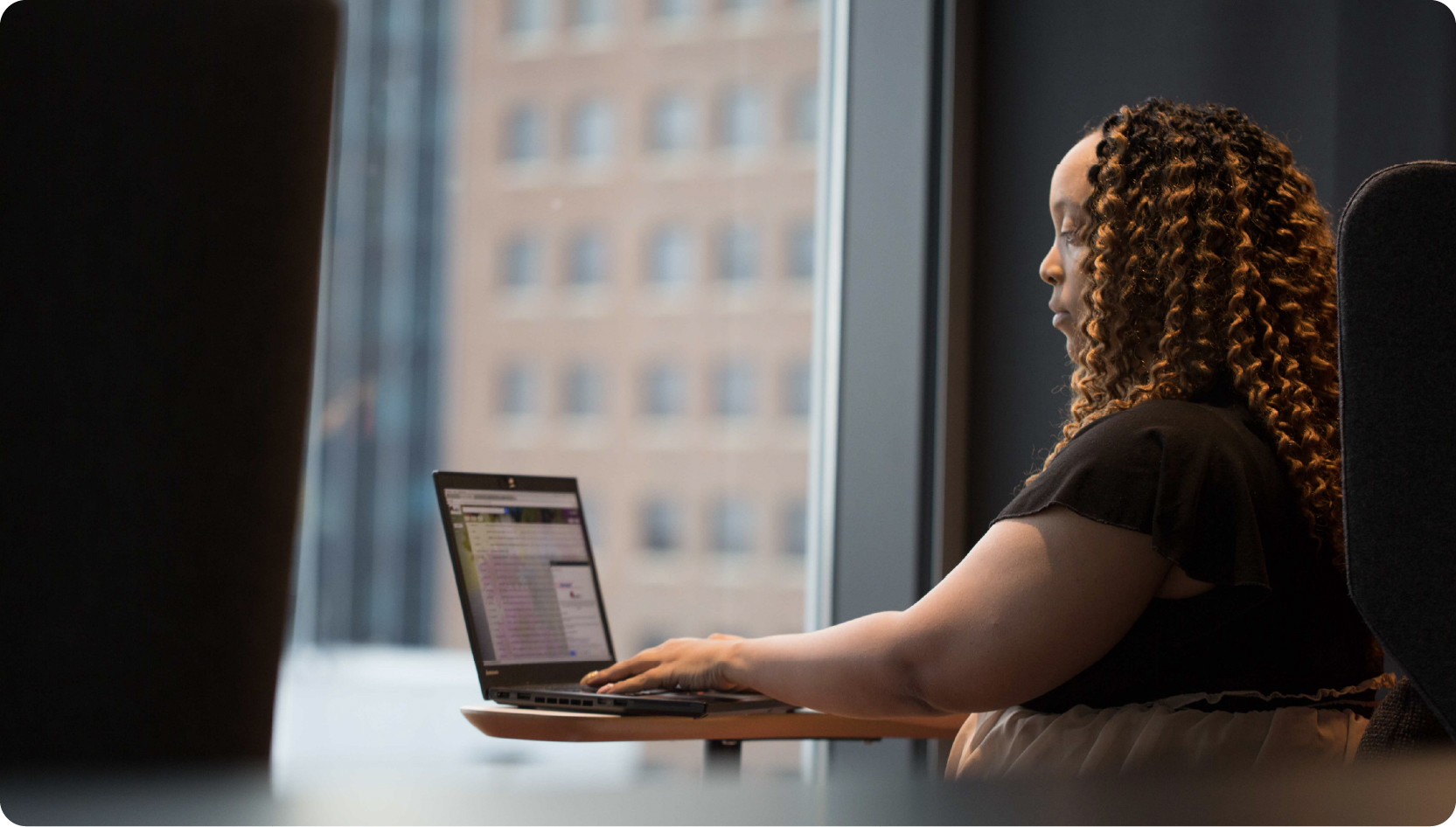 Photo of woman at her laptop in an office.