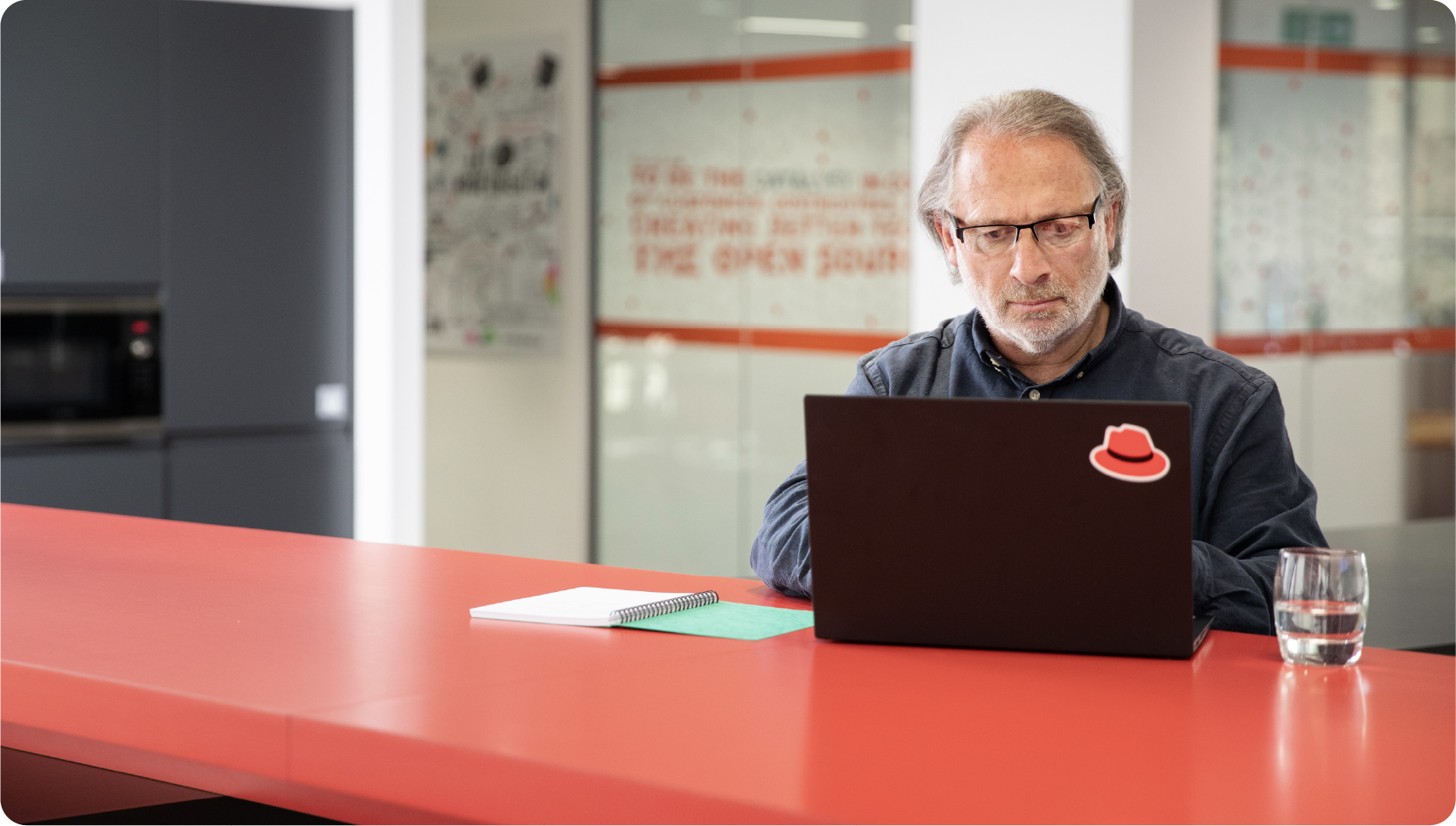 Photo of a person working on laptop in modern office.