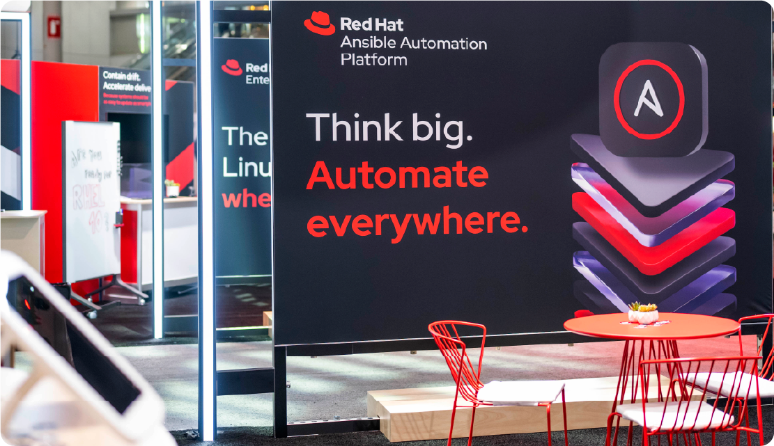 Photography of a signage at Red Hat Summit that uses the Red Hat Ansible Automation Platform 3D tech icon and 3D texture in a hybrid style collage